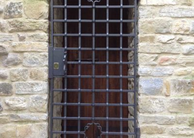 Portoncino in ferro battuto con elementi a barra bucata del Castello di Carbonana a Gubbio