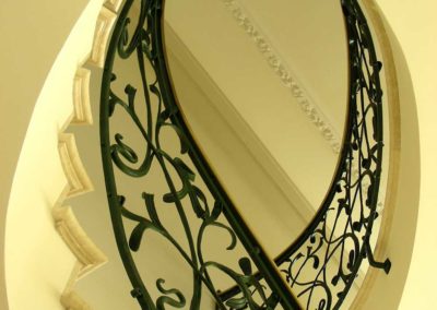 Scala in ferro battuto con foglie color verde inglese con motivi Liberty e corrimano in ottone in villa privata a Cap d'Ail