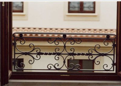 Parapetto in ferro battuto con motivi orizzontali e riccioli in palazzo Luxottica a Milan